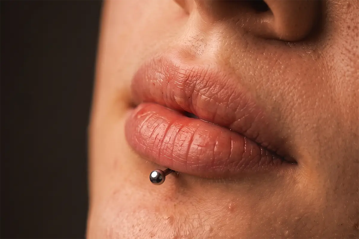 Labret piercing alt dudak merkezinde takı yerleşim örneği